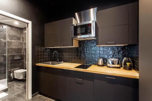 eine Küche mit braunen Schränken, einer Spüle und einer Mikrowelle in der Unterkunft CMG Friedland // Champs Elysées in Paris