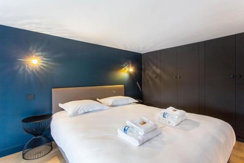 ein Schlafzimmer mit einem großen weißen Bett mit Handtüchern darauf in der Unterkunft CMG Friedland // Champs Elysées in Paris