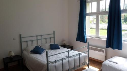 una camera da letto con un letto con tende blu e una finestra di Haras De Blingel a Blingel