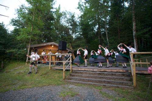 a group of people dancing on steps in front of a cabin at Hotel Gasthof Post in Nesselwang
