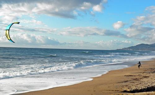 a person is flying a kite on the beach at Nepheli Hotel in Kastrosikia