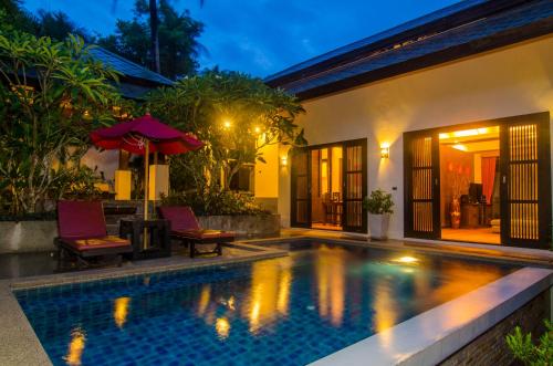 a villa with a swimming pool at night at Kirikayan Residences Koh Samui in Mae Nam