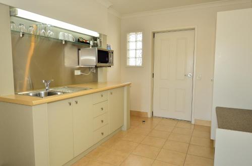 a kitchen with a sink and a microwave at Senator Motor Inn in Gisborne