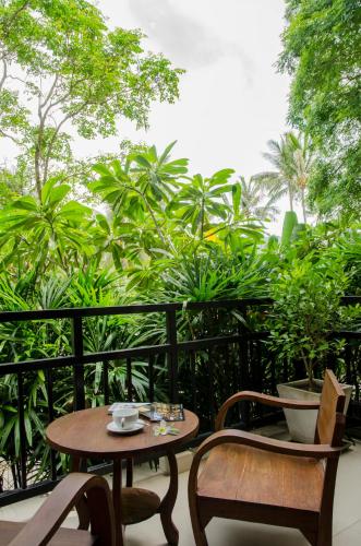 a table and chairs on a balcony with plants at Kirikayan Residences Koh Samui in Mae Nam