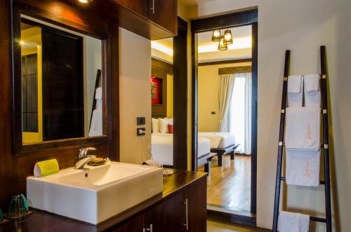 a bathroom with a sink and a large mirror at Kirikayan Residences Koh Samui in Mae Nam