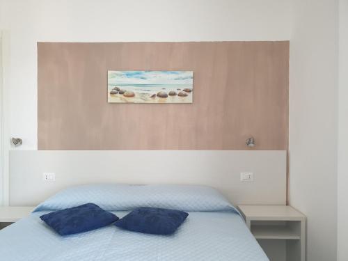 um quarto com uma cama com duas almofadas azuis em Caletta sul Mare em La Caletta