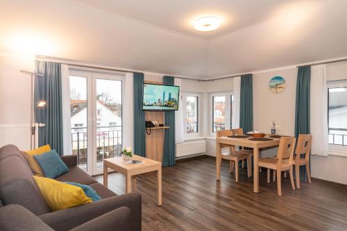 ein Wohnzimmer mit einem Sofa und einem Tisch in der Unterkunft BSW Ferienwohnungen Rügen in Baabe
