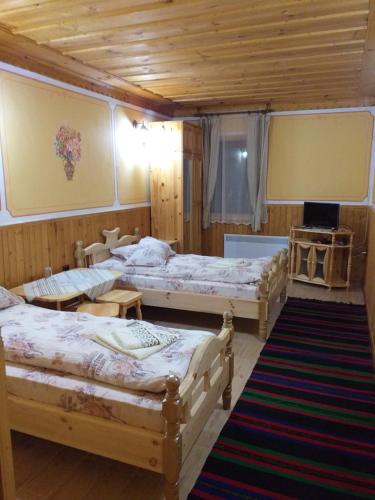 a bedroom with three beds in a room at Хотел Дончо Войвода in Koprivshtitsa