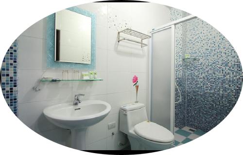 a bathroom with a sink and a toilet and a shower at Chang-an House B&B in Hualien City