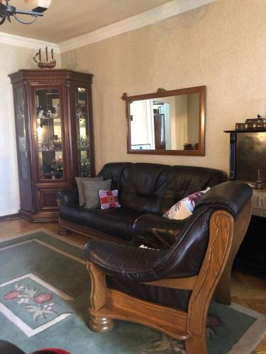 un soggiorno con un divano in pelle e uno specchio di DARIA a Tbilisi City