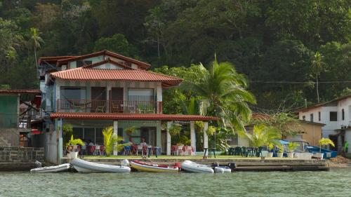 a house on the water with boats in front of it at Casa Congo & Casa Rayo Verde - Restaurante - Galeria de arte in Portobelo