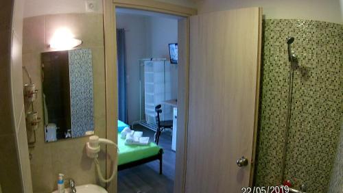 La salle de bains est pourvue d'une douche, d'un lavabo et d'un miroir. dans l'établissement KOSTAS FAMILY ROOMS, à Stavros