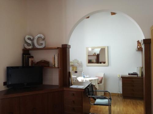 Zimmer mit einem TV und einem Schreibtisch mit einem Spiegel in der Unterkunft La casa di Simona in Pistoia