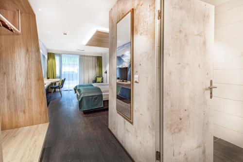 a room with a corridor with a bedroom and a mirror at Hotel sleep&stay - Self Check-in in Eglisau