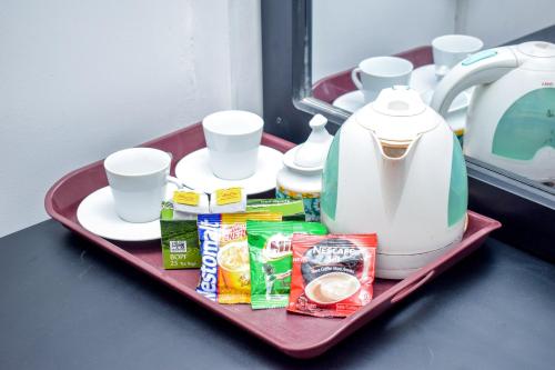 a tray with a tea kettle and other food on it at Lion Resort in Polonnaruwa