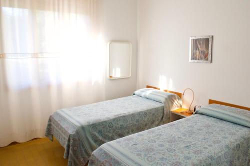 Habitación de hotel con 2 camas y ventana en VILLA CRISTINA N.05, en Lido di Jesolo