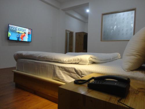 a room with two beds and a phone on a table at Hotel Rezang-La in Leh