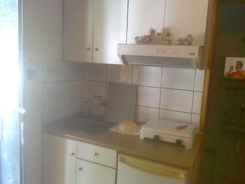 een kleine keuken met een wastafel en een broodrooster bij House Mantesos in Koinira