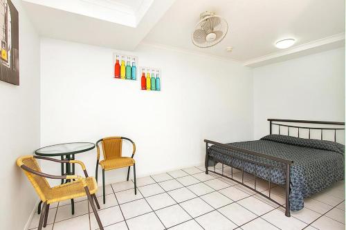 a bedroom with a bed and a table and chairs at Caravella Backpackers in Cairns