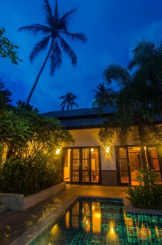a villa with a swimming pool at night at Kirikayan Residences Koh Samui in Mae Nam