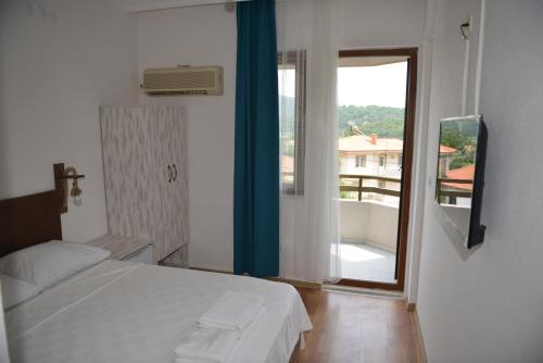 a bedroom with a bed and a large window at Double Comfort Otel in Muğla