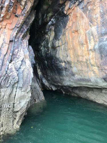a cave filled with water next to a cliff at Harbour Heights Guest House in Torquay