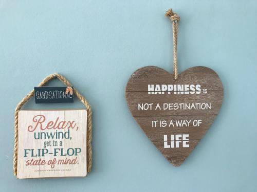 a wooden heart with a sign that says happiness not a destination at Harbour Heights Guest House in Torquay