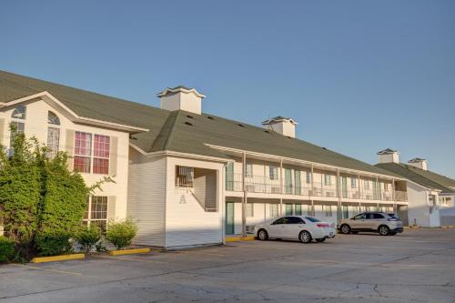 a building with two cars parked in a parking lot at Howard Johnson by Wyndham Branson Theatre District in Branson