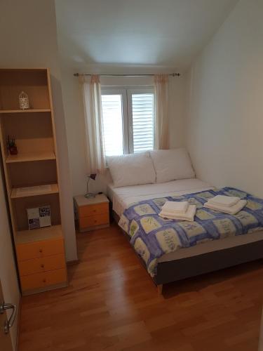 a small bedroom with a bed and a window at Marko Apartment in Korčula