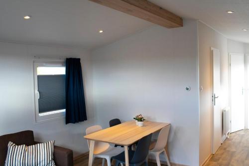 a dining room with a wooden table and chairs at Zuiderzee-chalet 22 in Molkwerum