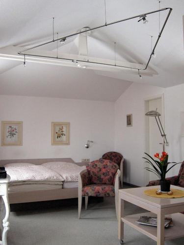 a bedroom with a bed and a chair and a table at Uns Gartenhus mit Blick auf das Meer in Thiessow