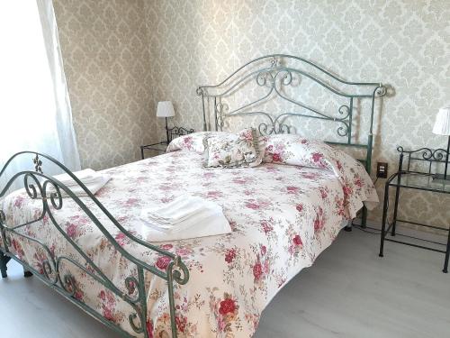 ルッカにあるAppartamento Elenaのベッドルーム1室(花柄のベッドカバー付)