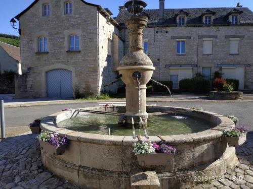 a water fountain in front of a building at Les Inseparables in Sévérac-lʼÉglise