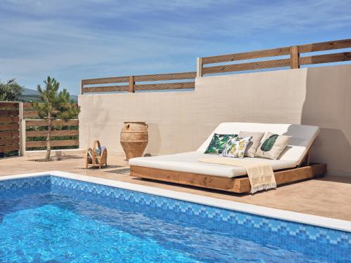 a bed on a patio next to a swimming pool at Lofos Soilis in Tragaki