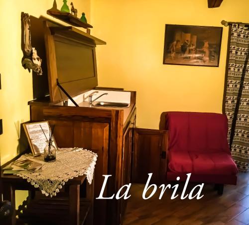 a living room with a red chair and a table at Agriturismo B&B Chèvres à Cheval in Aosta