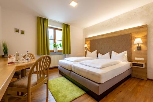 a hotel room with a large bed and a desk at Zur Post Kümmersbruck Hotel & Tiny Houses in Kümmersbruck