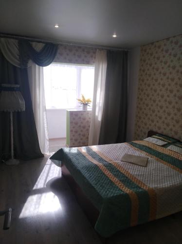 a bedroom with a bed in front of a window at 2 комнатная квартира in Gagra
