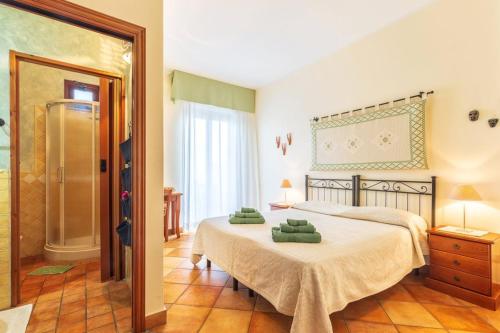 a bedroom with a large bed and a shower at Il Leccio in Tortolì