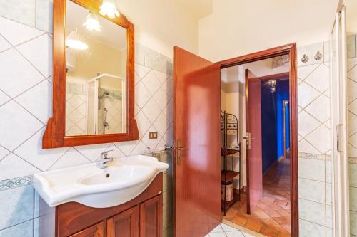 La salle de bains est pourvue d'un lavabo, d'un miroir et d'une douche. dans l'établissement Il Leccio, à Tortolì