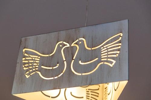 a sign with two birds on top of a light at Il Leccio in Tortolì