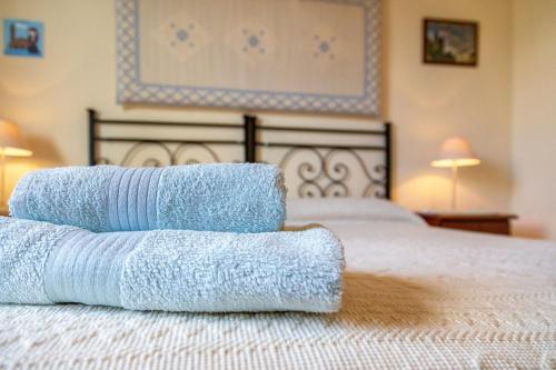 a pile of towels sitting on top of a bed at Il Leccio in Tortolì