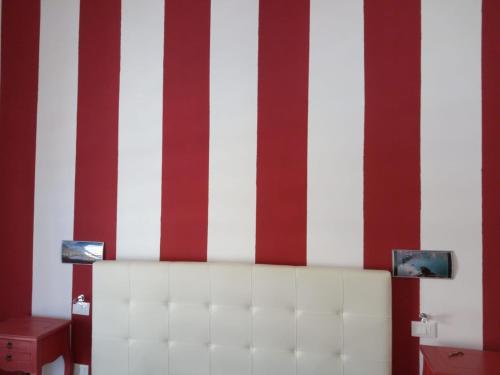 a room with red and white stripes on a wall at La Melagrana in Castellammare del Golfo