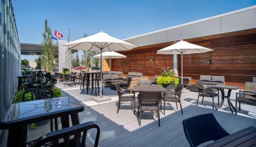 a patio with tables and chairs and umbrellas at Hotel Blackfoot in Calgary
