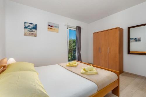 een slaapkamer met een bed met gele handdoeken erop bij Apartman Roza in Ičići