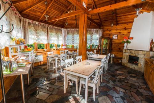 een eetkamer met tafels en stoelen en een open haard bij Willa Dusia in Międzyzdroje