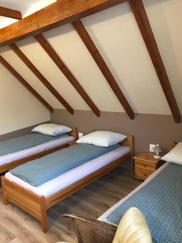 2 letti in una camera con soffitti in legno di Pokoje u Marysi a Łeba