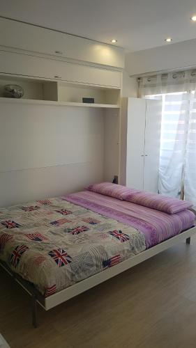 um quarto com uma cama grande e um edredão roxo em alex appartement em Roquebrune-Cap-Martin