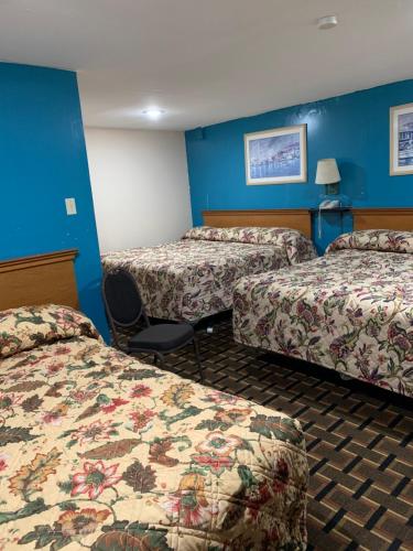 a hotel room with two beds and blue walls at Blue Falls Motel in Tonawanda