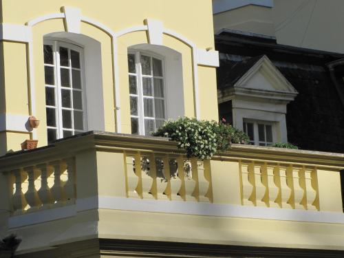 a yellow building with a balcony with flowers on it at Haus Annaberg in Bonn