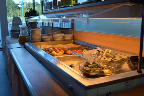 una línea de buffet con muchos platos diferentes de comida en Turmöl Hotel, en Allhaming